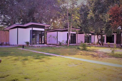 a pink building with a grass yard and trees at Serene Resort in Pai