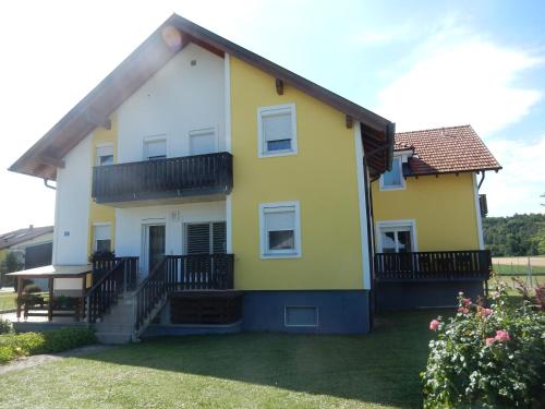 a yellow and white house with a yard at Appartement Huber in Lutzmannsburg