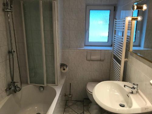 ein Badezimmer mit einem Waschbecken, einer Badewanne und einem WC in der Unterkunft IFAM - Ihr Ferienhaus am Main in Zellingen