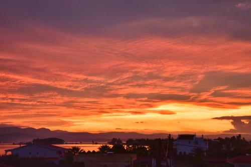 a sunset over a city with a red sky at Avantis Suites Hotel in Eretria