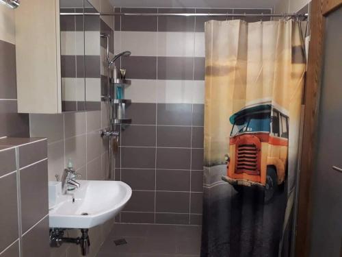 a bathroom with a shower curtain with a van on it at Elijos apartamentai in Šventoji