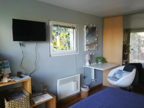 Cette chambre comprend un lit et une télévision murale. dans l'établissement Grand studio avec piscine, à Montpellier