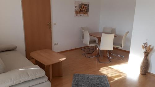 a living room with a table and white chairs at Appartement Huber in Lutzmannsburg