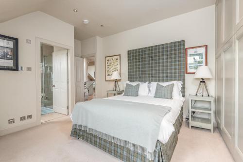 a bedroom with a large bed with a green headboard at Spectacular Penthouse , 100 yds to Old Course , Balcony in St Andrews