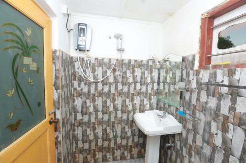 a bathroom with a sink and a shower curtain at Galle Paradise Inn in Galle