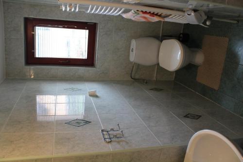 a bathroom with two toilets and a sink and a window at Marko Apartmány in Oščadnica