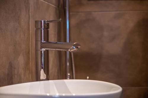 a bathroom sink with a water faucet at Nissaki Suite Poseidon by Sealand Villas in Nisakion