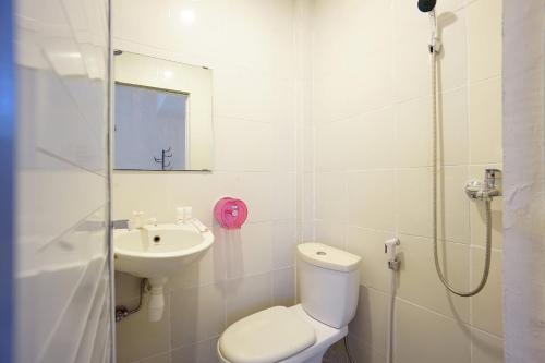 uma casa de banho com um WC e um lavatório em OYO 1838 COZY Home em Manado