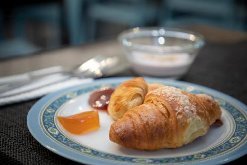 einen Teller mit einem Croissant und anderen Speisen auf einem Tisch in der Unterkunft Ideal City Walk in Neapel