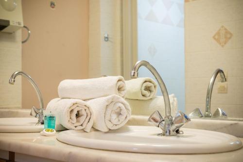 bagno con 2 lavandini, asciugamani e specchio di Bravo Apartments a Laganas