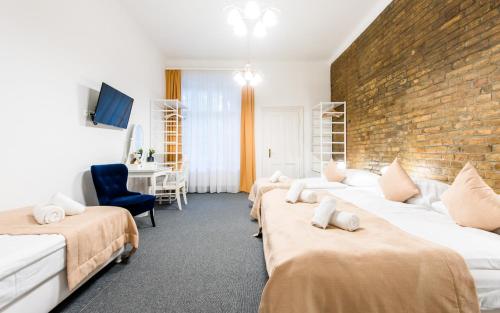 a room with three beds and a brick wall at Downtown Bratislava B&B in Bratislava