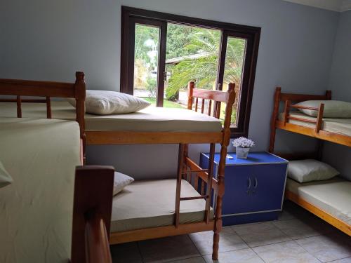 um quarto com 3 beliches e uma janela em iUP HOUSE Hostel em Blumenau