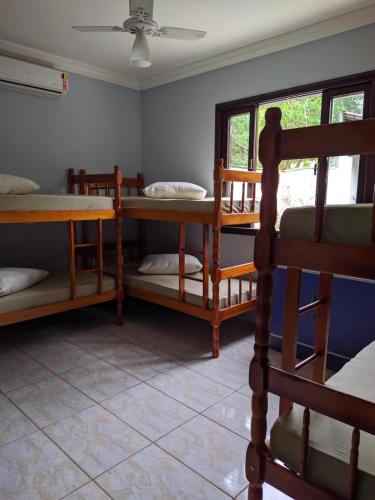 a room with several bunk beds and a window at iUP HOUSE Hostel in Blumenau