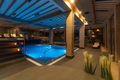 a swimming pool in a building with lights at Helan Family & SPA in Zakopane