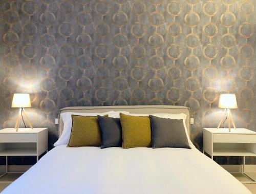 バーリにあるLAUS Teatro Petruzzelli Suiteの2つのランプが付いた白いベッドのある寝室