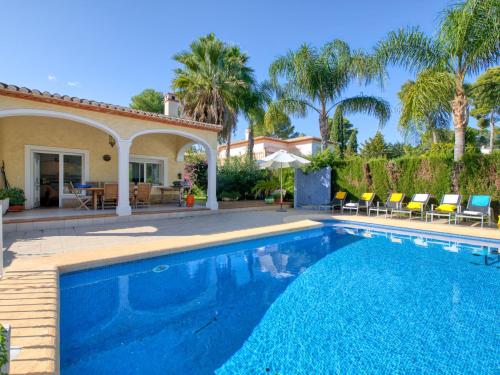 a swimming pool in front of a house with palm trees at Villa Eucaliptus by Interhome in Balcon del Mar