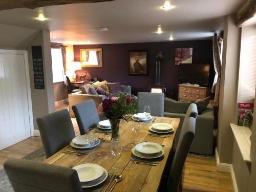 une table en bois avec des chaises et une salle à manger dans l'établissement Shippon Cottage - Brosterfield Farm, à Eyam