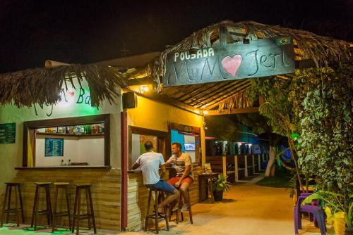 two people sitting outside of a bar at night at Pousada MYM JERI ate 3x in Jericoacoara