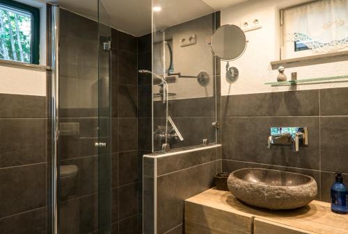y baño con lavabo de piedra y ducha. en Jungholz Chalet 65 en Jungholz