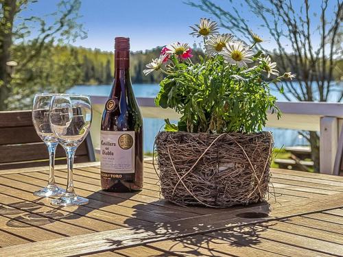 una bottiglia di vino e bicchieri su un tavolo con una pianta di Holiday Home Pajaranta by Interhome a Hara