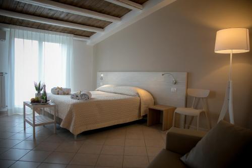 Musmelia Rooms - Affittacamere في Mussomeli: غرفة نوم بسرير ومصباح وأريكة
