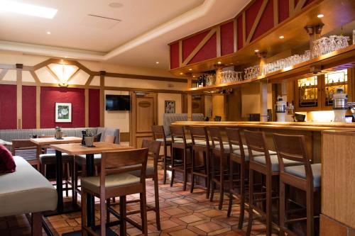 a bar in a restaurant with wooden tables and chairs at Bundt's Hotel & Gartenrestaurant in Hamburg