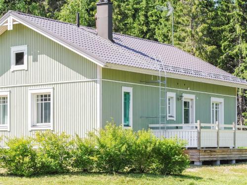 ein grünes und weißes Haus mit einer Veranda in der Unterkunft Holiday Home Kaisla by Interhome in Torvoila