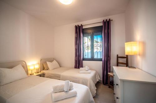 Habitación de hotel con 2 camas y ventana en Cozy holiday home in the beach, en Marbella