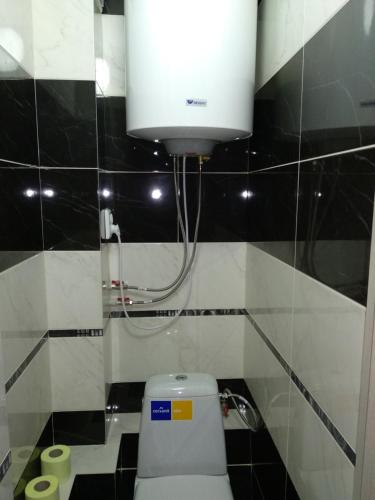 een badkamer met een toilet met een licht erboven bij Вернадського 4 CityRooms in Bila Tserkva