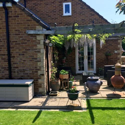 a garden with a pergola and some plants at Bub Lane Cottage in Christchurch