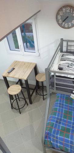 Cette chambre comprend une table, un lit, une table et un tabouret. dans l'établissement studio mezzanine 5 personnes, à La Roche