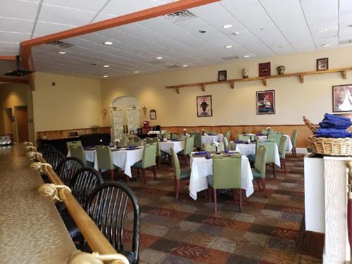 a dining room with white tables and green chairs at Chateau Resort & Conference Center in Tannersville