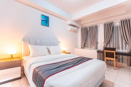 a bedroom with a bed and a desk and windows at SUPER OYO Collection O 24 Patraland Urbano in Bekasi