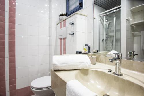 Garden Toscana Resort في سان فينتْشينسو: حمام مع حوض ومرحاض