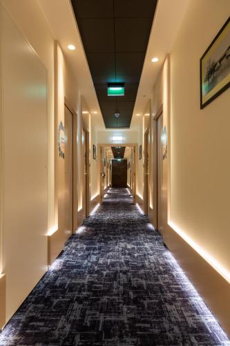 an empty hallway in a building with lights on the ceilings at ibis Styles Chaves in Chaves