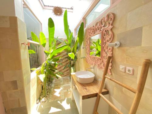La salle de bains est pourvue d'un lavabo, d'un miroir et de plantes. dans l'établissement Flamingo, à Gili Trawangan