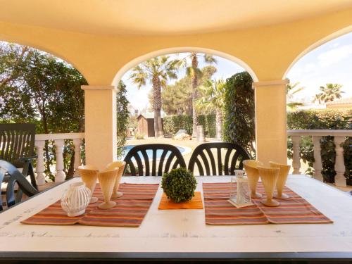 una mesa con platos y cuencos en un porche en Holiday Home El Jardi by Interhome, en Riumar