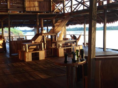 a room with a wooden floor with bottles on a table at Cabaña Flotante Kurupira in Leticia