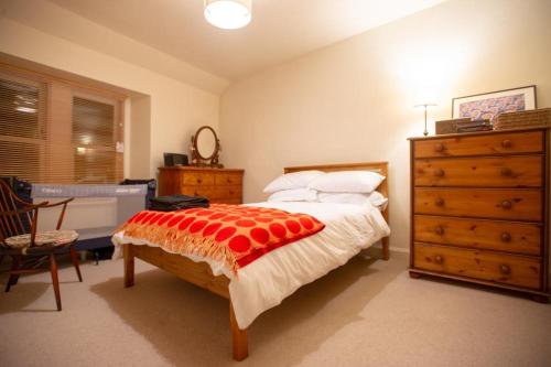 a bedroom with a large bed with a dresser and a dresser at Bank Street Gallery in Kirriemuir