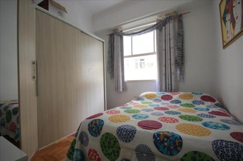1 dormitorio con 1 cama con un edredón colorido en Felipe de Oliveira Apartment, en Río de Janeiro