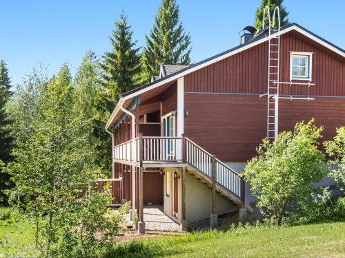 ein großes rotes Haus mit Balkon und Bäumen in der Unterkunft Holiday Home Tintintupa by Interhome in Tahkovuori