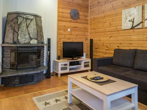 ein Wohnzimmer mit einem Sofa und einem Kamin in der Unterkunft Holiday Home Tintintupa by Interhome in Tahkovuori