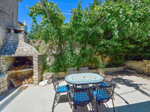 a patio with a table and chairs and a stone fireplace at Holiday Home Dubravka by Interhome in Osor