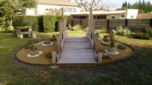 a wooden walkway in a yard with potted plants at Masribou2 in Barbentane