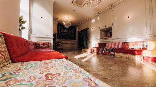 a living room with a red couch in a room at Hotel Babula am Augarten in Vienna