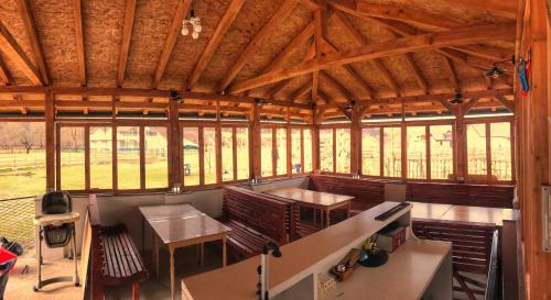 an inside view of a pavilion with tables and chairs at Riverside Guesthouse & Sauna in Vusanje