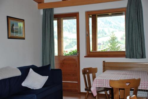 a living room with a couch and a table and a window at Aria d'Bosch in Badia