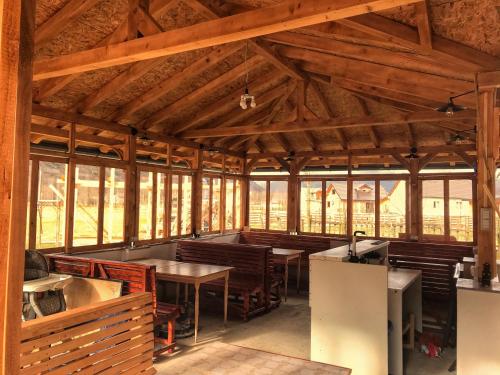 a dining room with tables and chairs and windows at Riverside Guesthouse & Sauna in Vusanje