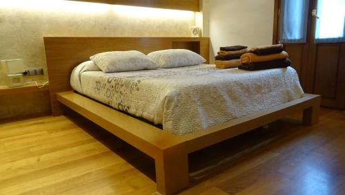 1 dormitorio con 1 cama grande y cabecero de madera en Gaztanbide Apartamento rural, en Ochagavía