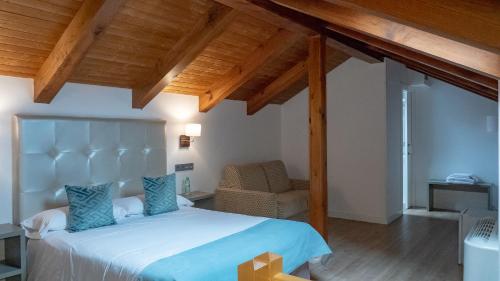 1 dormitorio con 1 cama grande y 1 silla en Hab Urban Hostel en Segovia